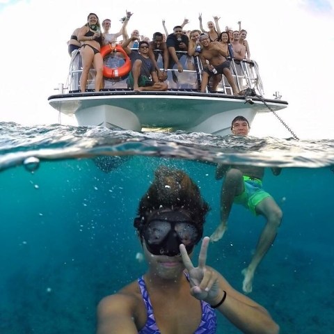 woman snorkeling and boat with people