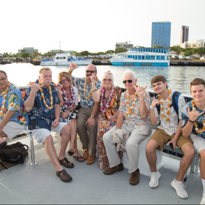 a group of people sitting on a bench posing for the camera