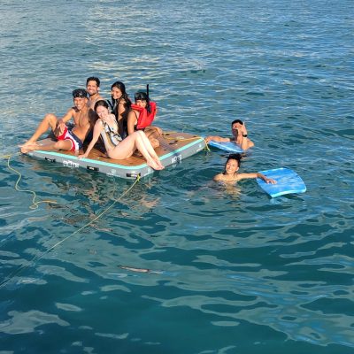 a group of people riding on the back of a boat in the water