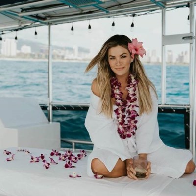 a woman sitting next to a body of water