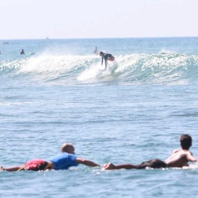 a group of people riding on top of a wave in the ocean
