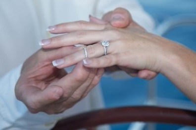 Hands exchanging wedding rings, close-up view.